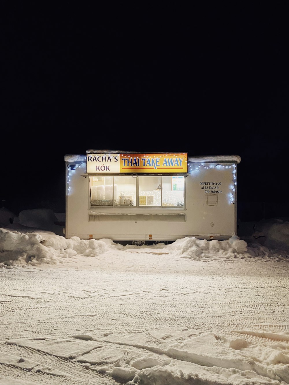 white and blue wooden building on snow covered ground during daytime