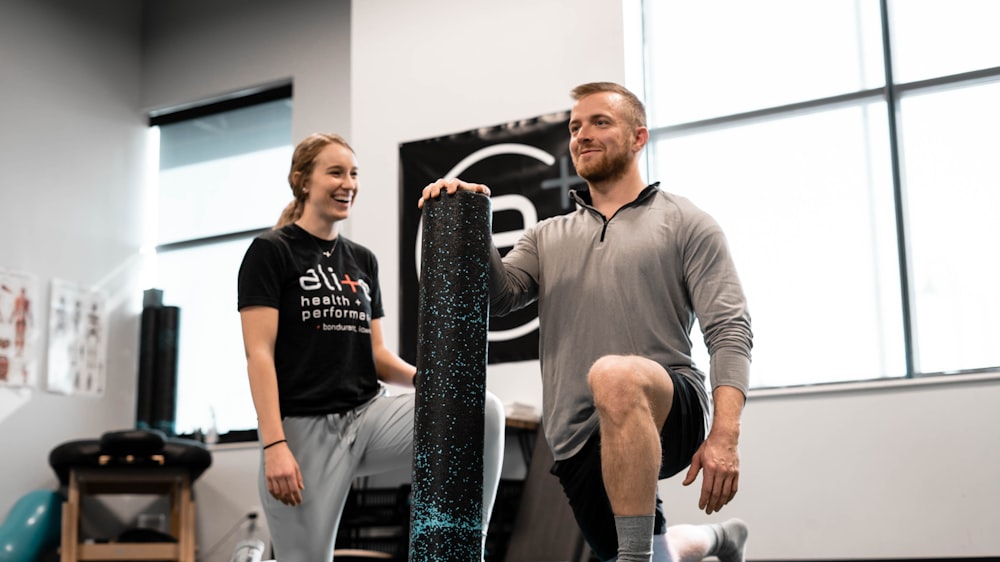 man in gray crew neck long sleeve shirt holding black and white skateboard