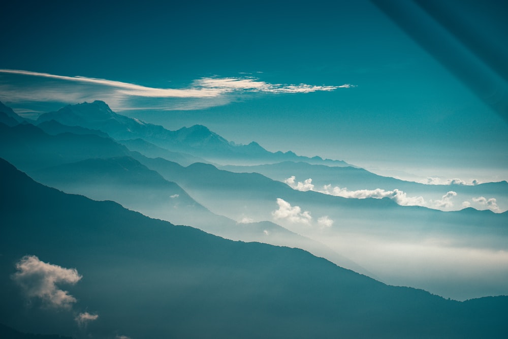 white clouds over mountains during daytime