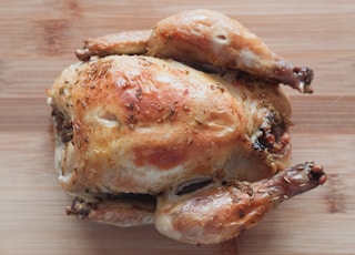 roasted chicken on brown wooden chopping board