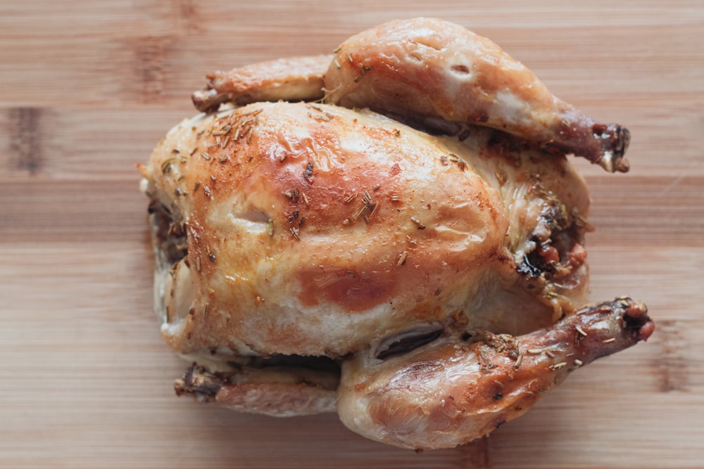 roasted chicken on brown wooden chopping board