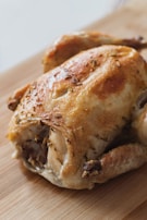 Hands slicing tender, juicy meat from a freshly roasted chicken, ready to serve.