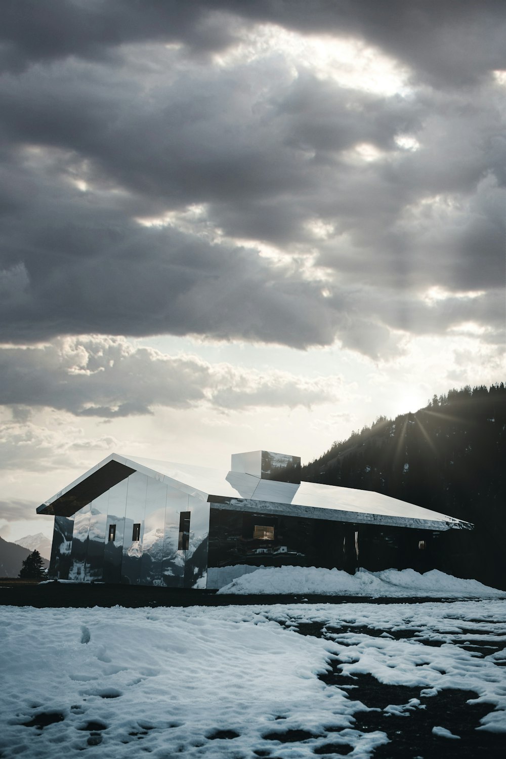 Casa bianca e nera vicino allo specchio d'acqua sotto il cielo nuvoloso durante il giorno