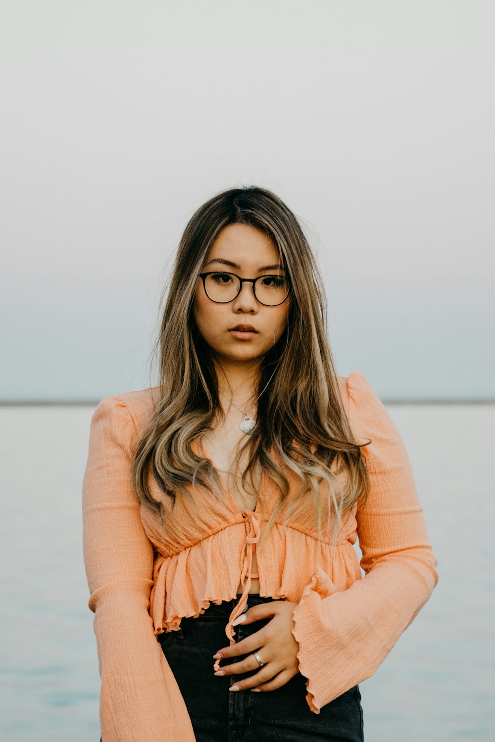 woman in brown long sleeve shirt wearing black framed eyeglasses