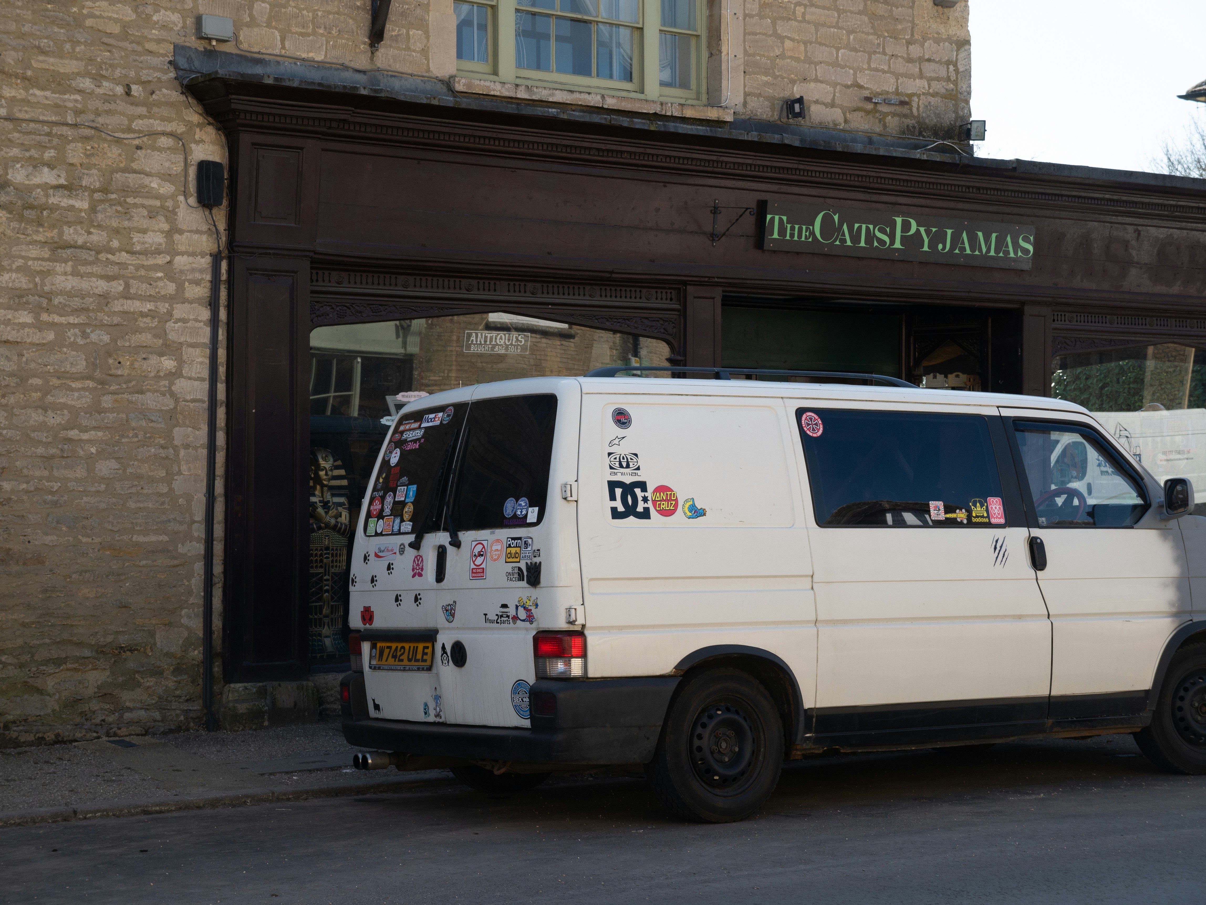 white van parked in front of green and white building