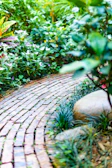 Curved brick walkway winding through a lush Jacksonville garden.