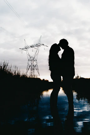 A romantic couple portrait framed by twilight and subtle violet hues.