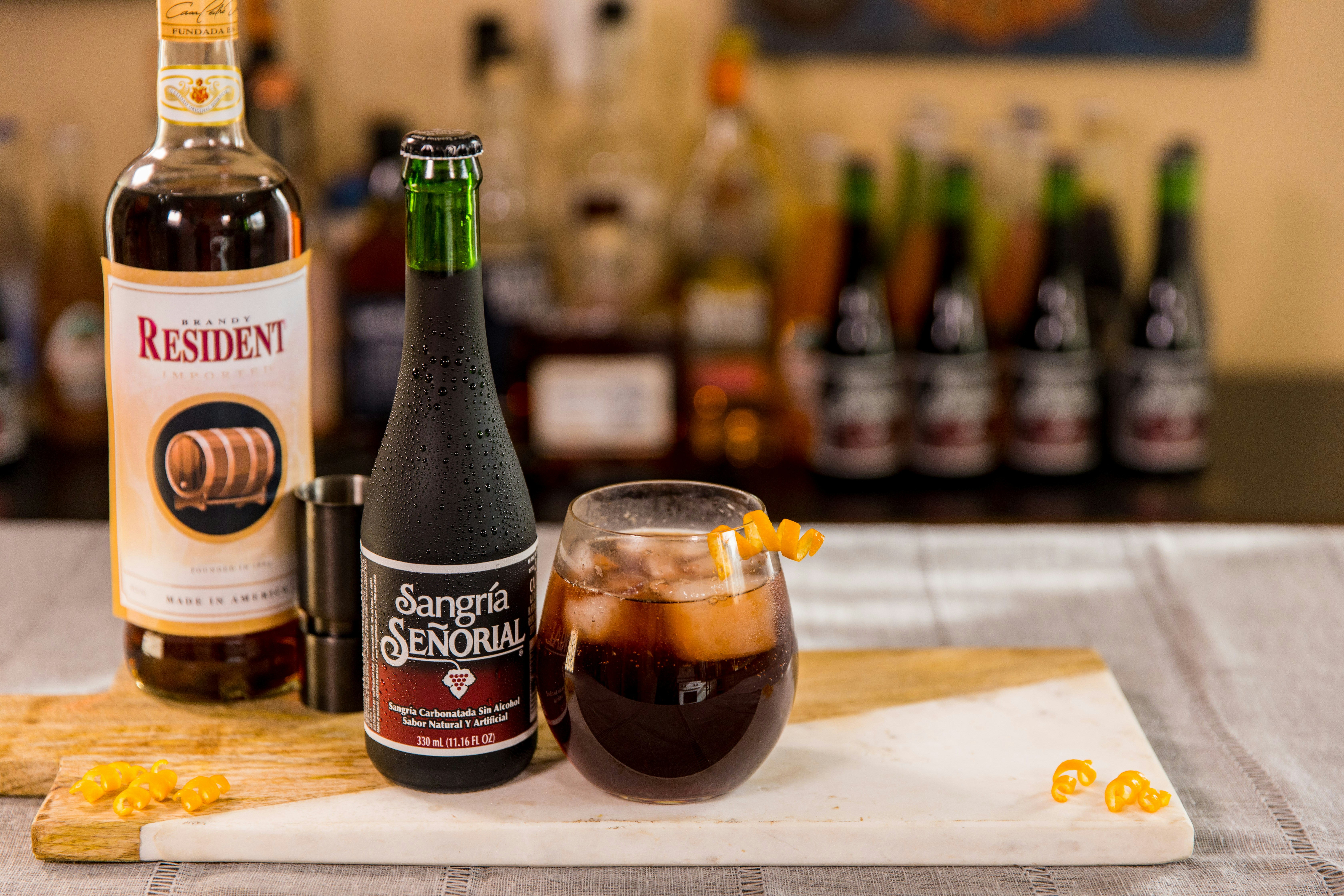 black and white labeled bottle beside clear drinking glass