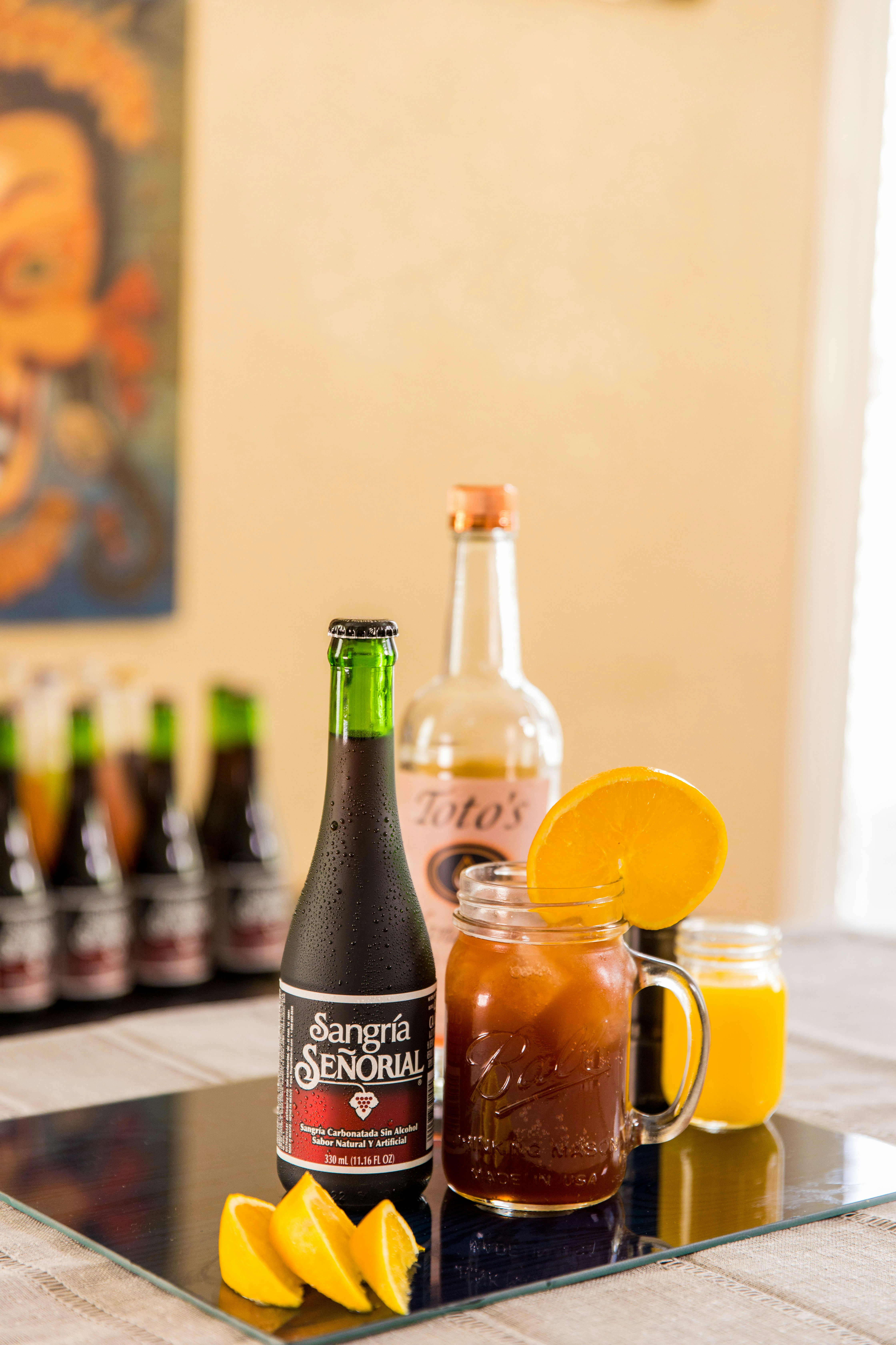 botol berlabel hitam di samping mug kaca bening