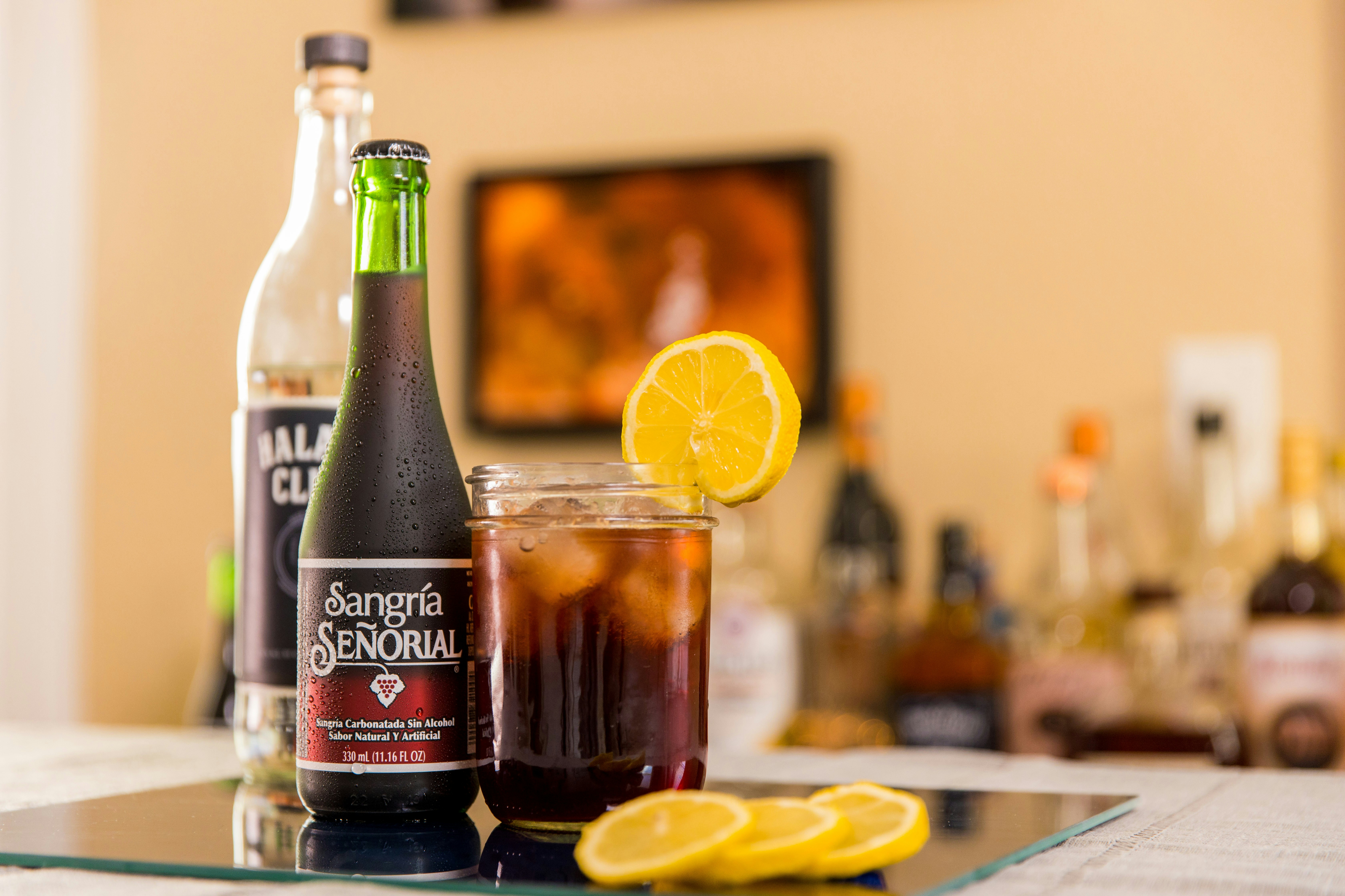 selective focus photography of black labeled bottle beside sliced lemon on table