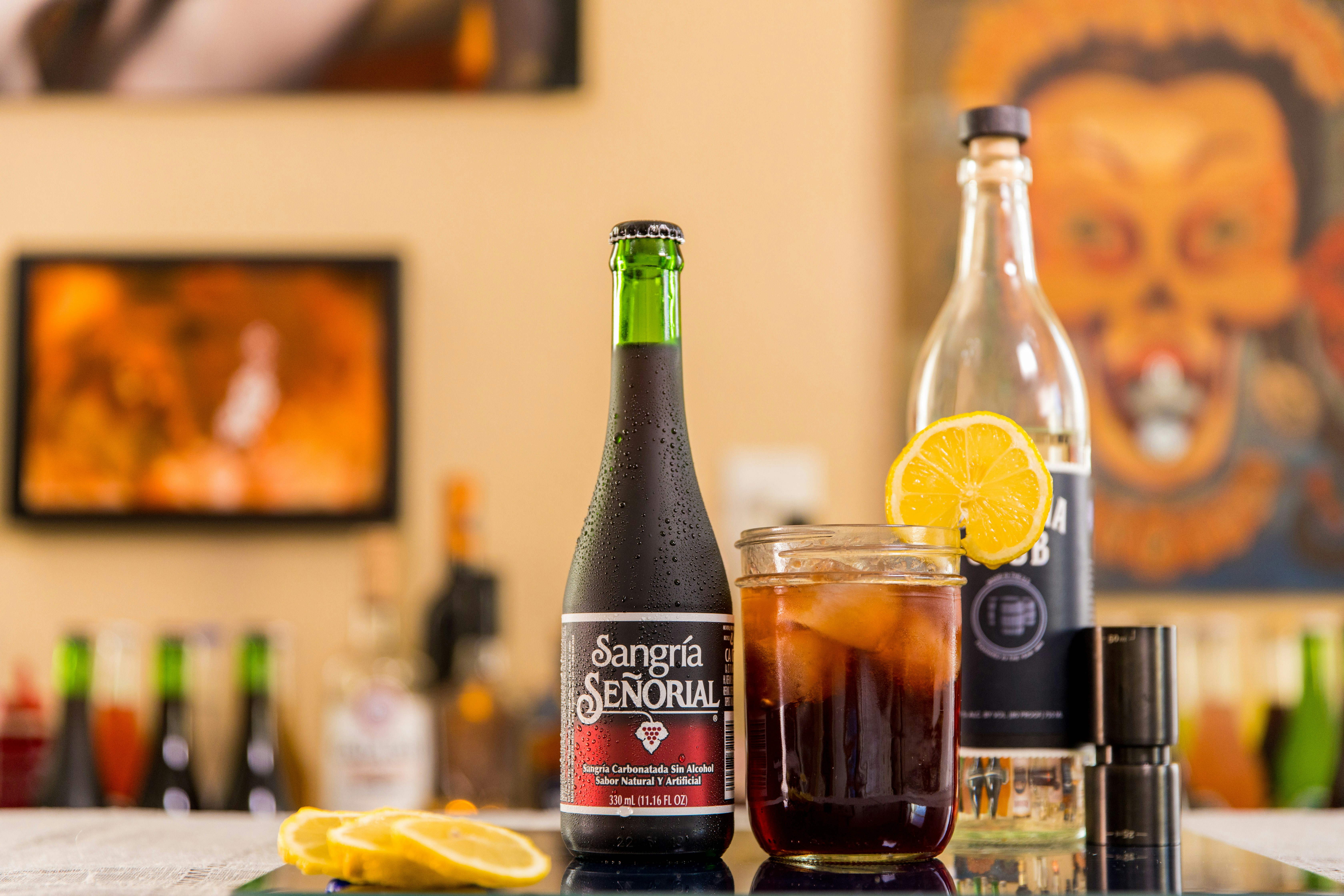 Botol Coca Cola Zero di samping Gelas Minum Bening