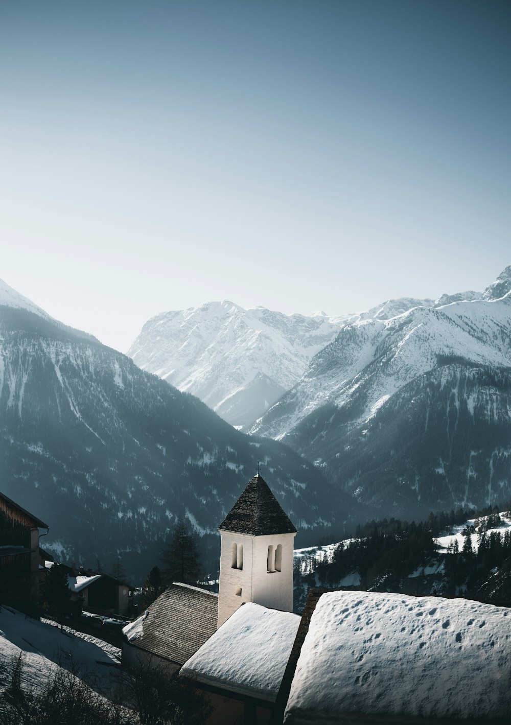 white and brown concrete building on snow covered ground near snow covered mountains during daytime