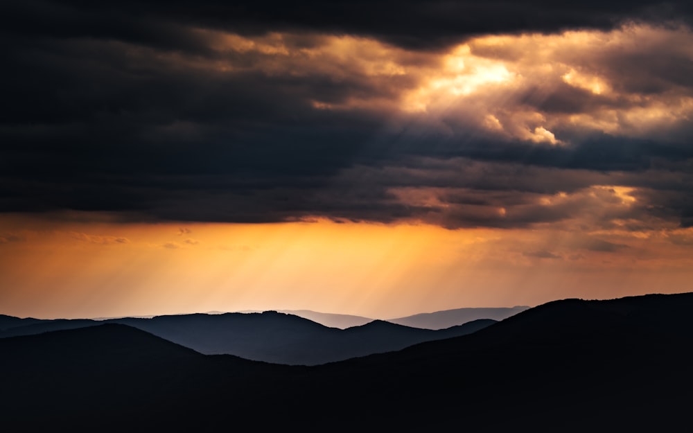 Silueta de montañas durante la puesta de sol