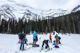 A group of friends laughing and preparing their gear before hitting the slopes.