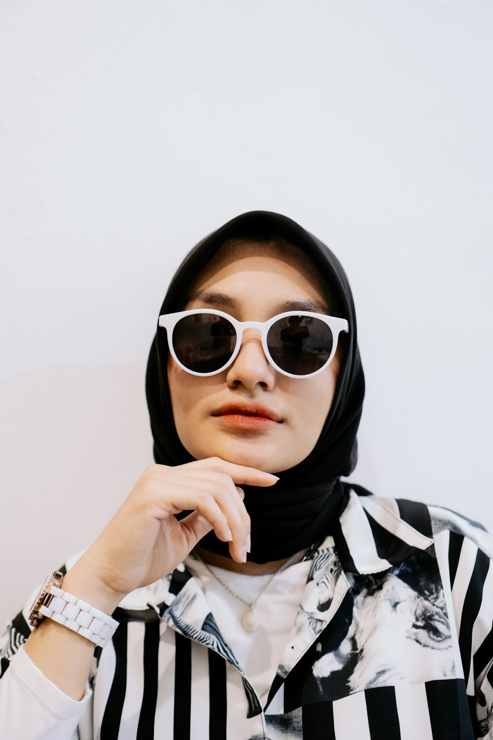 woman in black hijab and white and black long sleeve shirt wearing black sunglasses