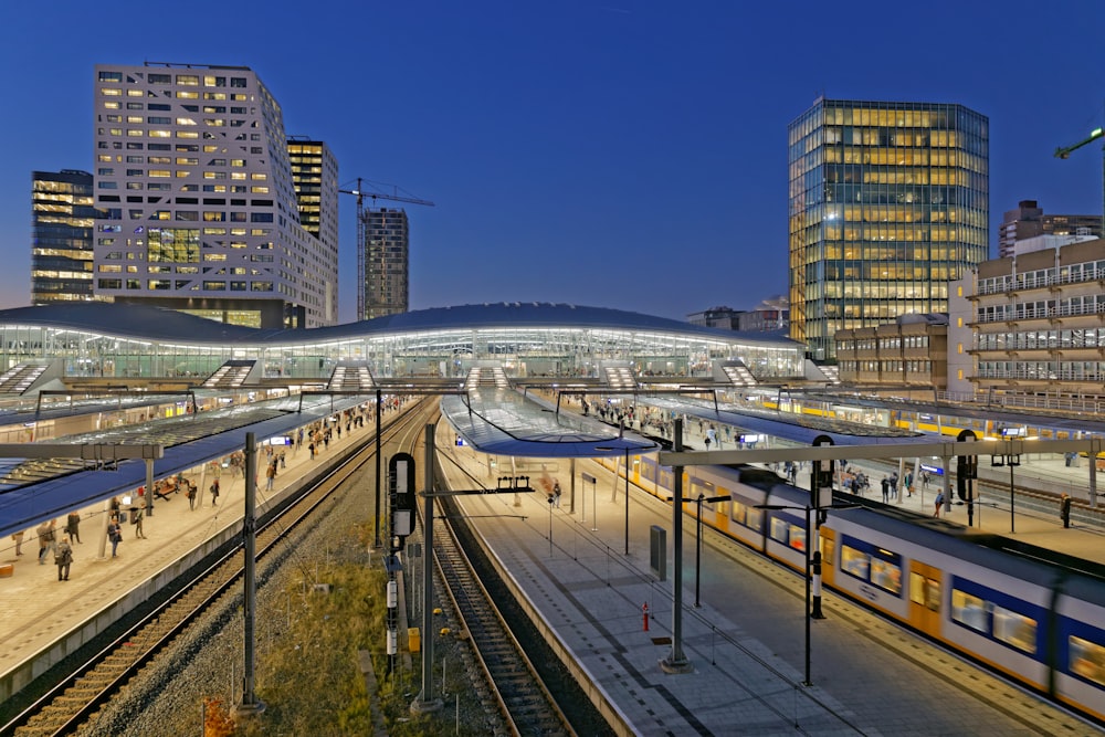 white and blue train on rail tracks during night time