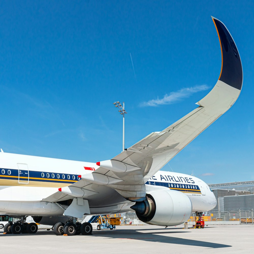 white and blue airplane on airport during daytime