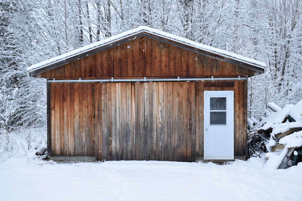 brown wooden house on snow covered ground