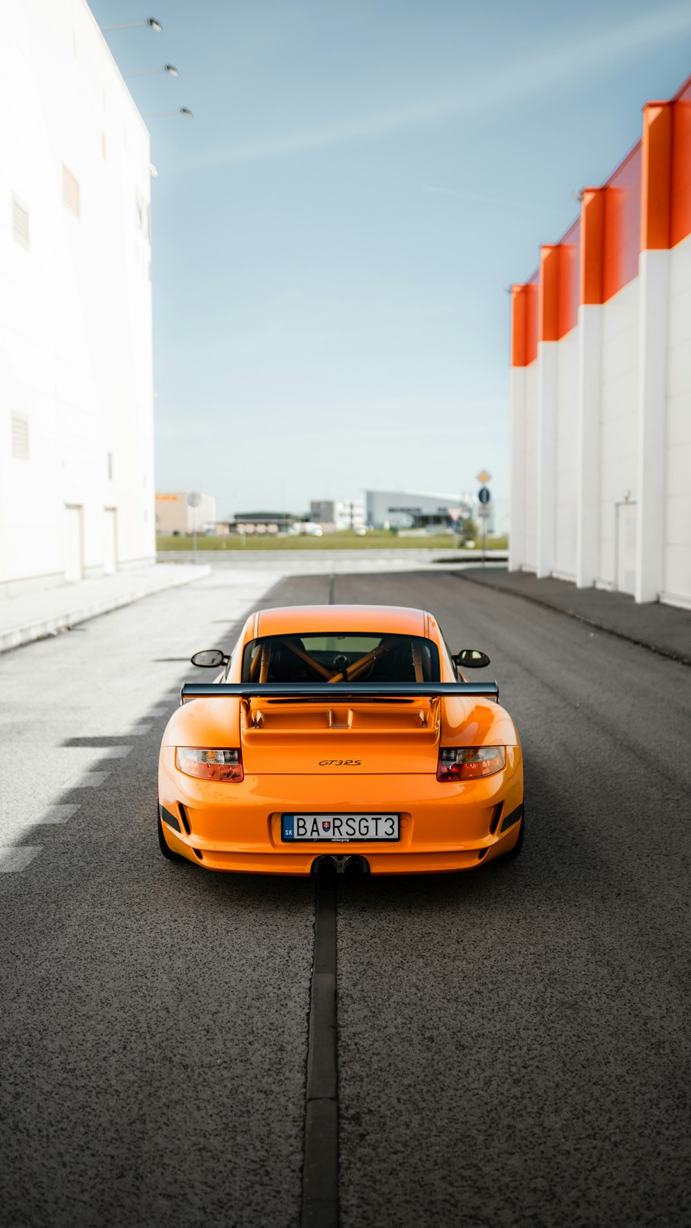 Porsche 911 arancione su strada durante il giorno