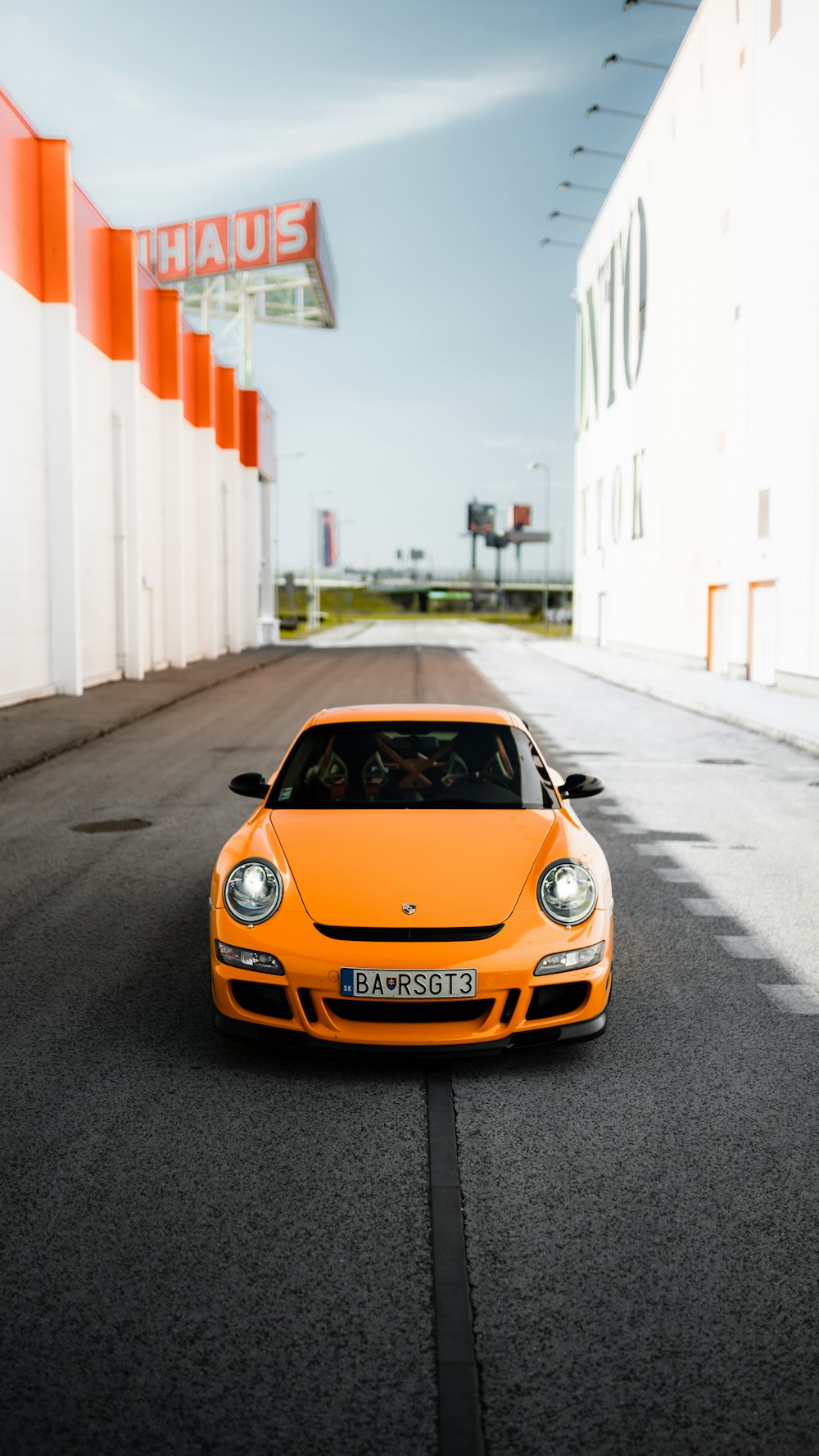 Orangefarbener Porsche 911 tagsüber unterwegs