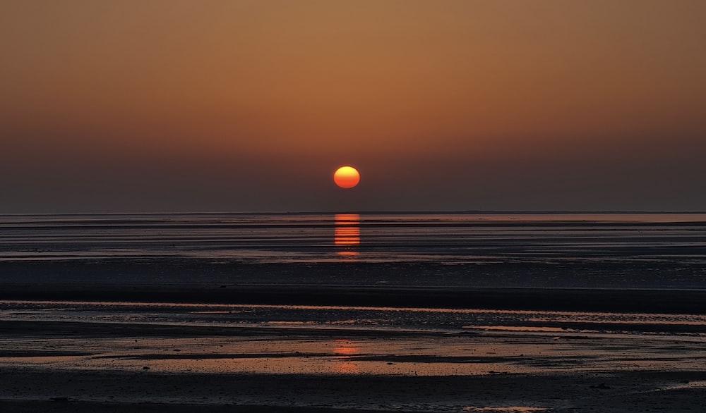 Puesta de sol sobre el mar con playa