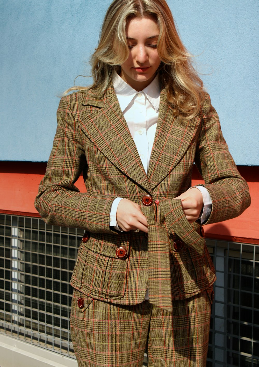 woman in brown and black plaid blazer standing