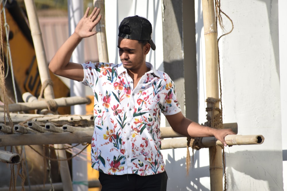 man in white blue and red floral button up shirt and black cap