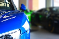 Close-up of a freshly painted car panel reflecting the shop’s signature dark blue and gold colors.