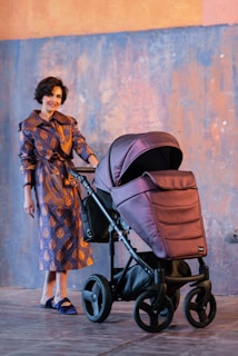woman in brown and black floral dress standing beside black stroller