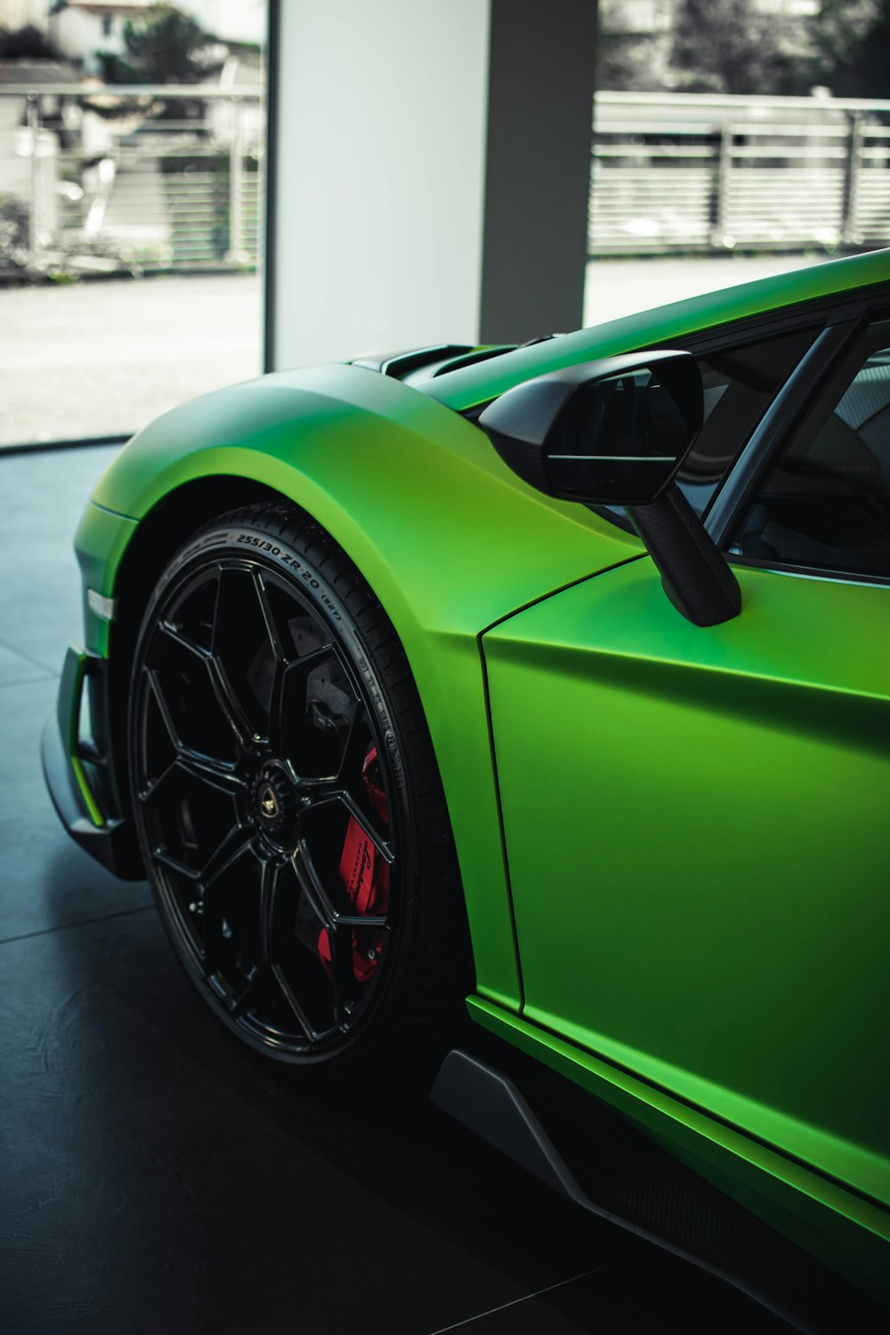 green car on gray asphalt road during daytime