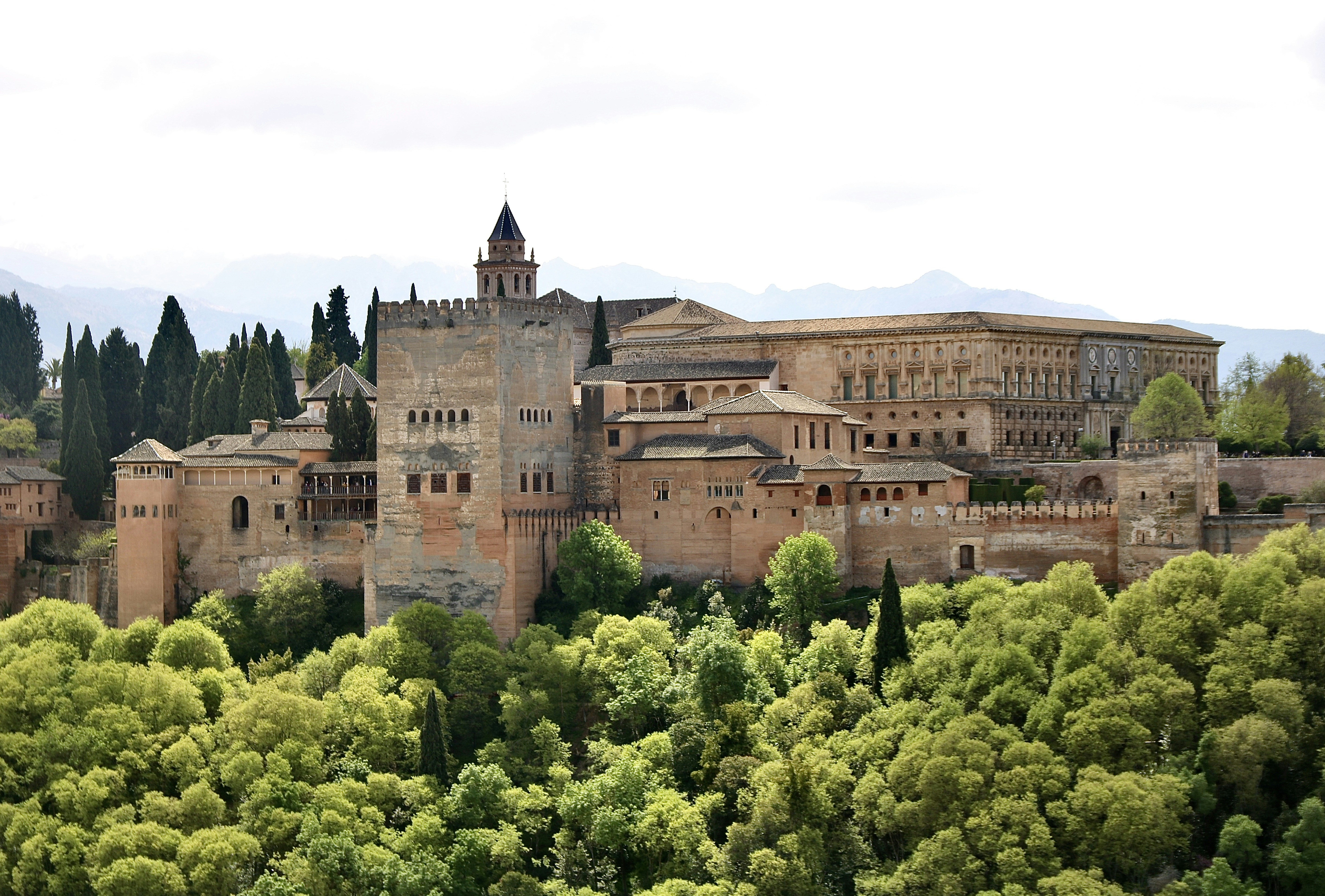 brown concrete building near green trees during daytime, 