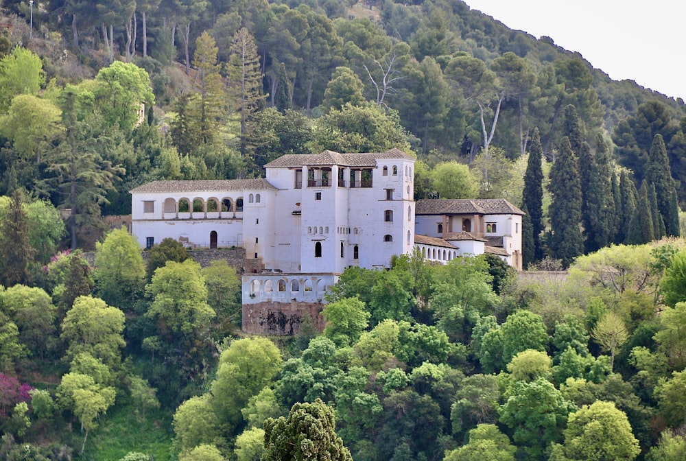 white concrete building surrounded by green trees during daytime