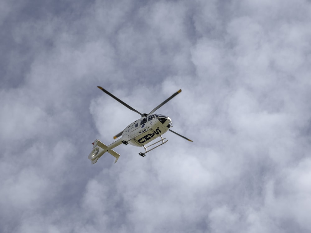 white and black helicopter flying in the sky