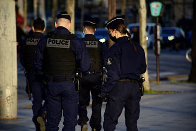 Uniformed security personnel conducting a thorough patrol around a commercial property at dusk.