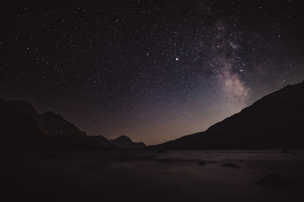 silhouette of mountains under starry night