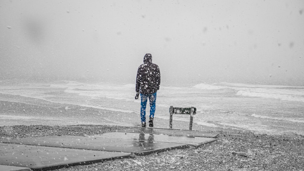 man in black and white checkered dress shirt standing on snow covered ground during daytime