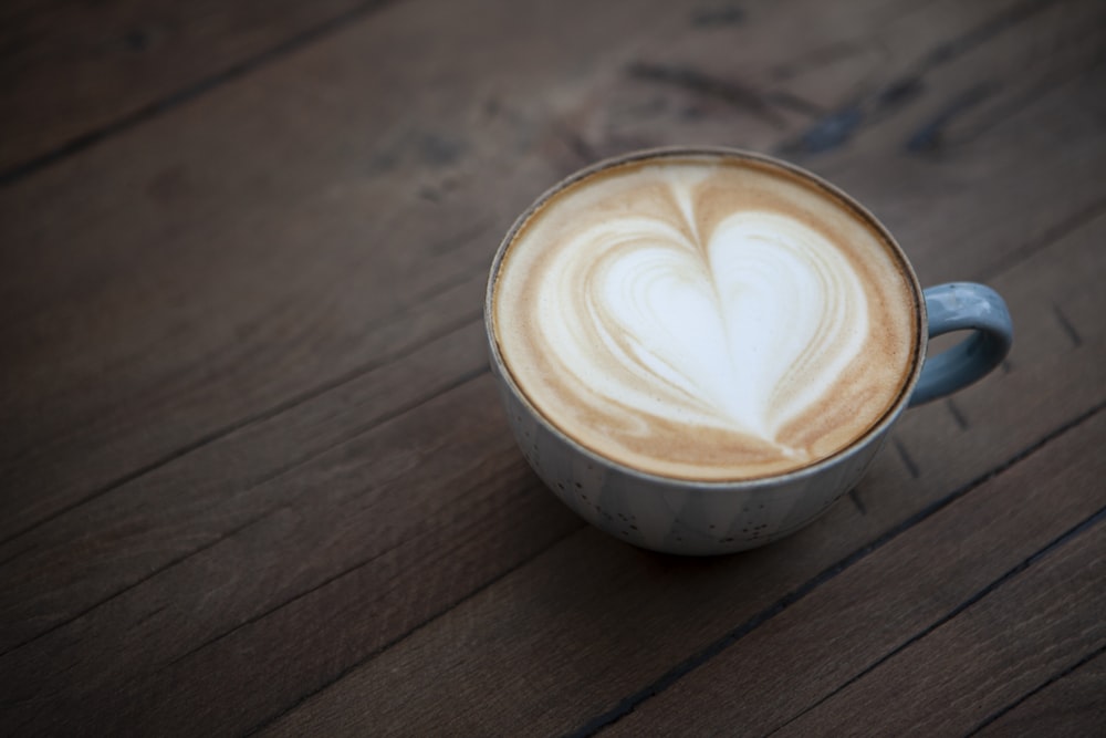 white ceramic cup with heart shaped coffee