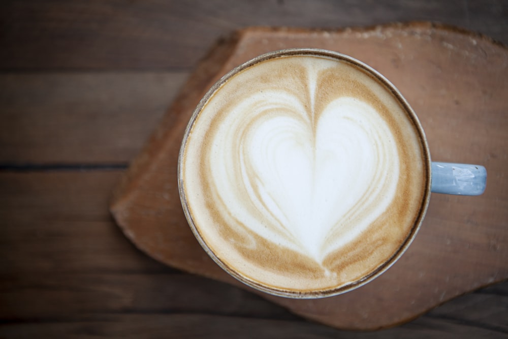 Cappuccino en forme de cœur sur table en bois brun