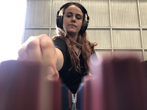 Close-up of jrealityg in the studio, headphones on, focused on mixing a new track.