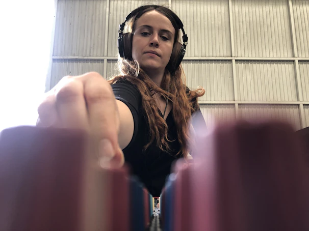 Close-up of Arkkay in the studio, headphones on, deeply focused on mixing tracks