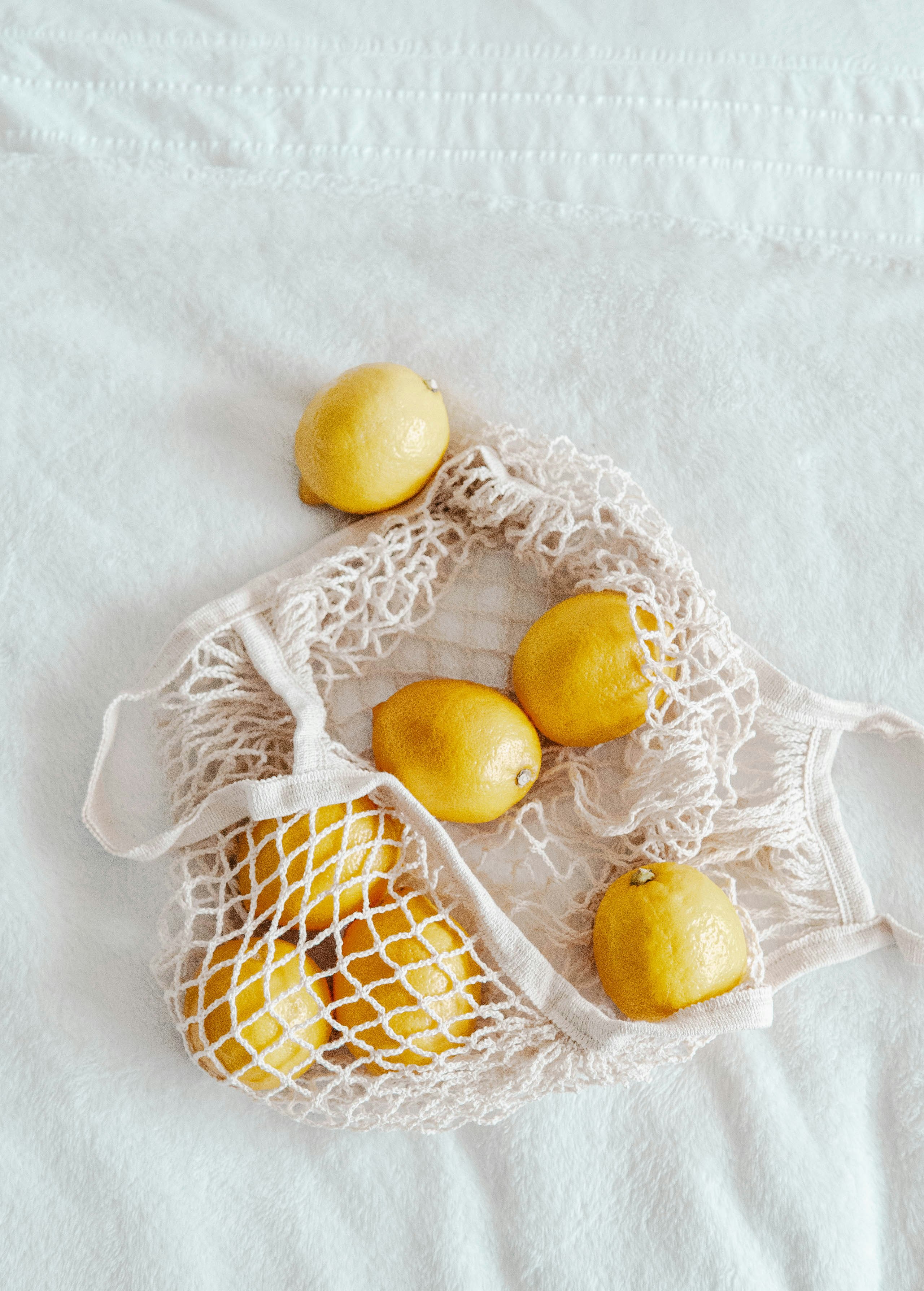 yellow citrus fruit on white lace textile