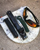 black framed sunglasses on gray and white marble table