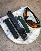 black framed sunglasses on gray and white marble table