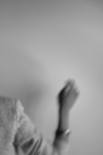 Grey-scale video still of a person walking in minimal casual clothing, highlighting fabric movement.