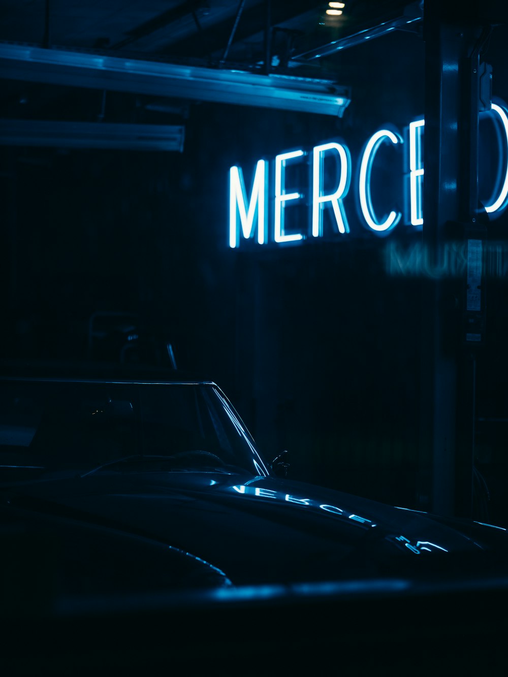 black car in front of blue and white open neon light signage