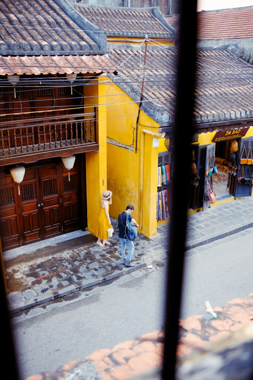 man in yellow shirt walking on sidewalk during daytime