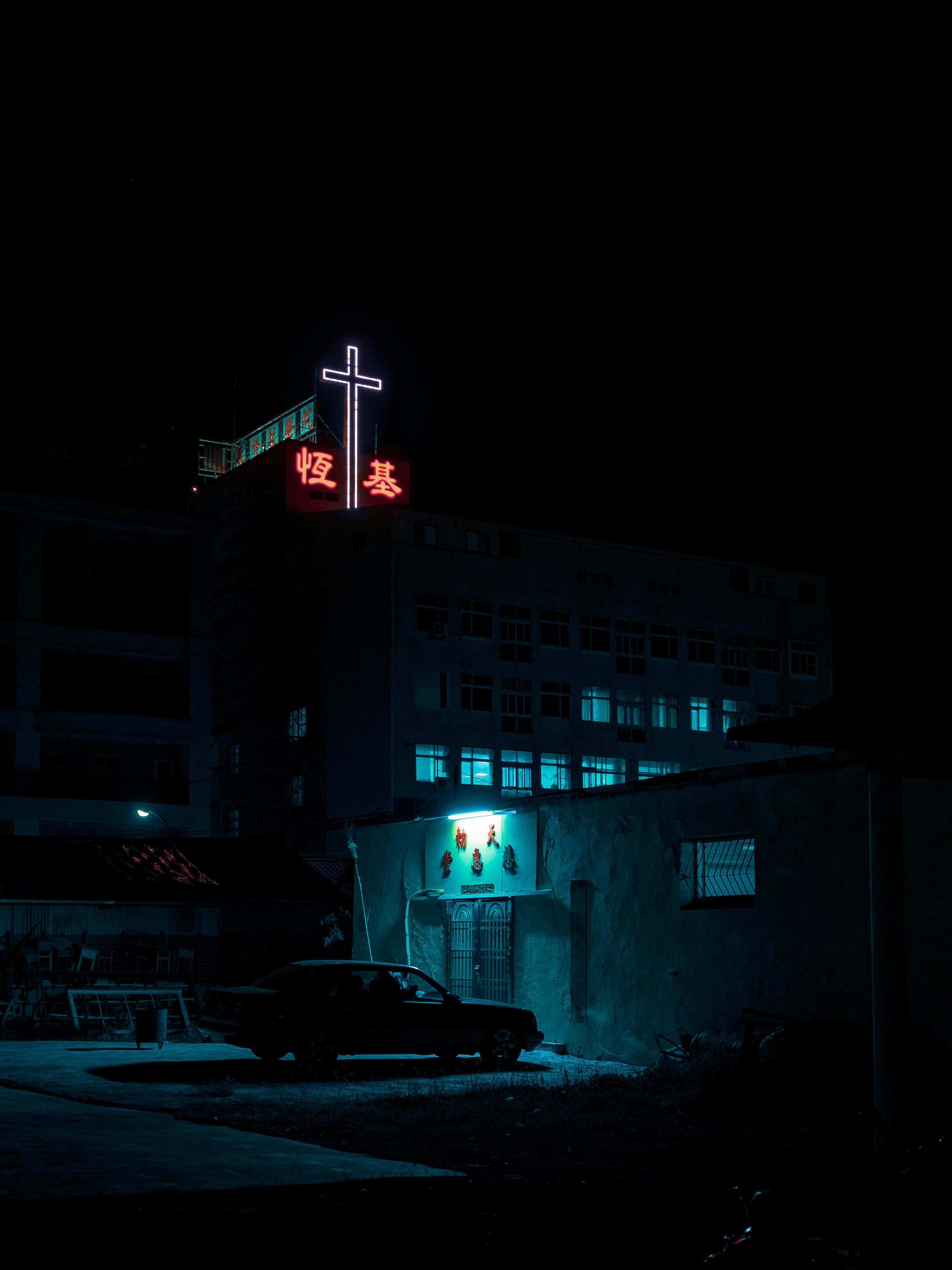 white and black cars parked near white concrete building during nighttime