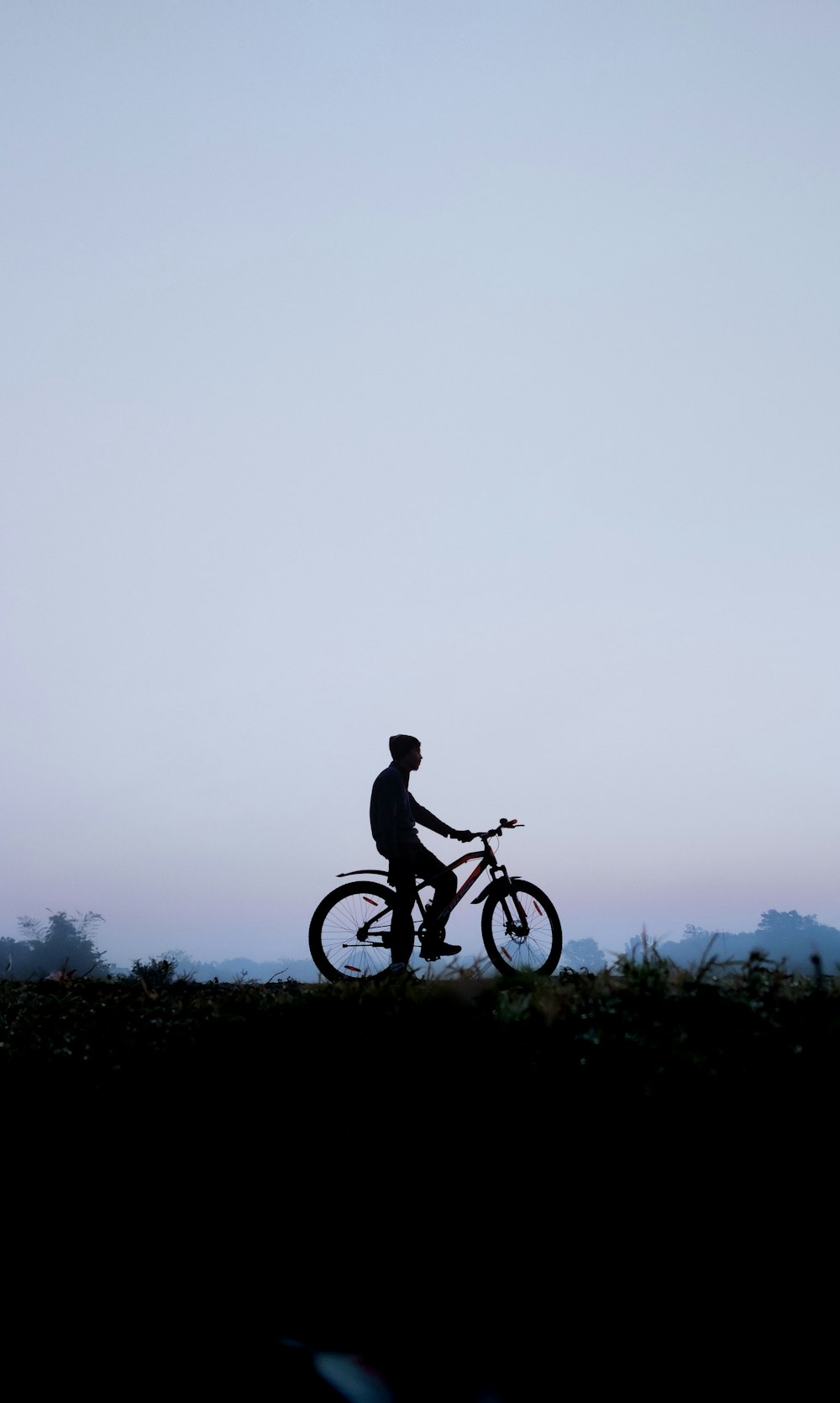 man riding bicycle on green grass field during daytime