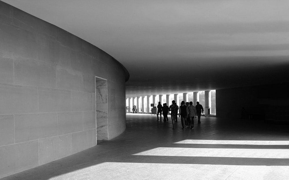 people walking on hallway in grayscale photography