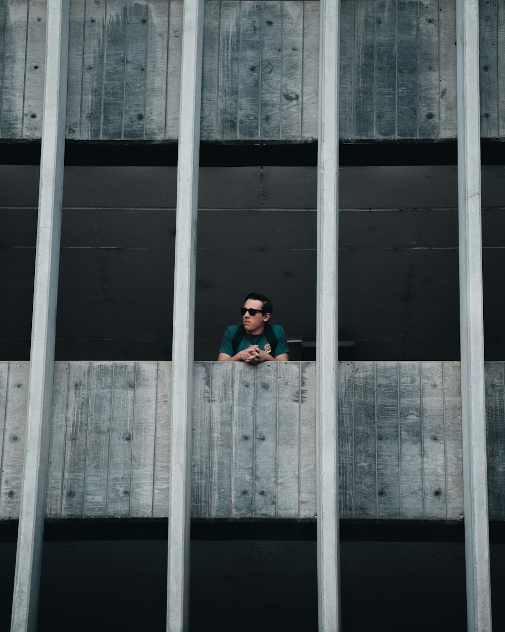 man in blue jacket sitting on the window